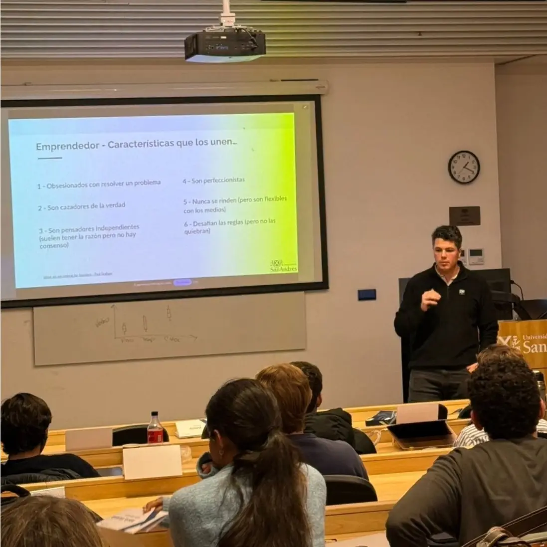 Clase de Entrepreneurship frente a estudiantes, con la presentación proyectada