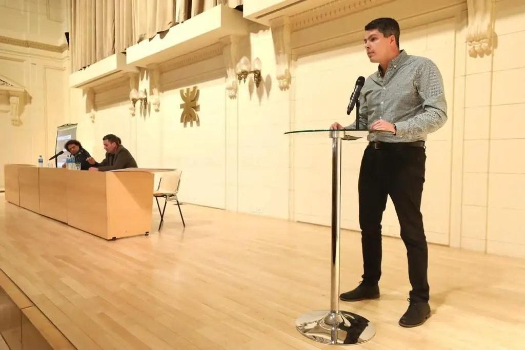 Octavio exponiendo desde el atril de un auditorio